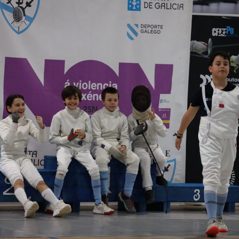 Grupo de nenos sorrintes con traxe de esgrima.